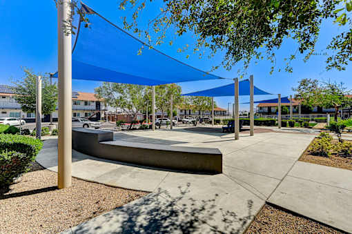 A playground with a blue canopy and a concrete structure.