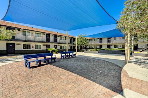 A courtyard with benches and a building in the background.