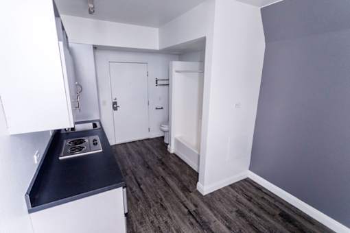 A kitchen with a stove top oven and a white cabinet.