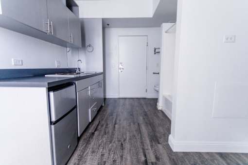 A kitchen with a stainless steel dishwasher and a white door.