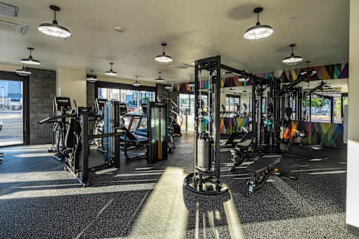 A gym with a variety of equipment including treadmills, weights, and exercise machines.