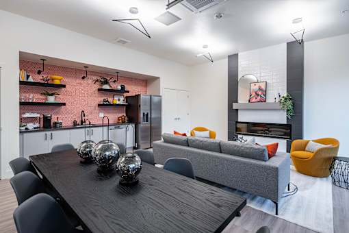 A modern dining room with a wooden table and grey couch.