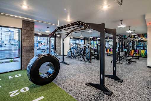 A gym with a green floor mat and a tire on it.