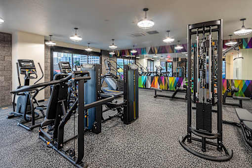 A gym with a variety of equipment including treadmills, weights, and exercise machines.