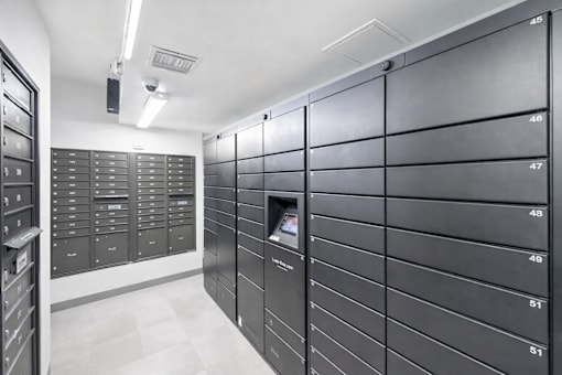 A row of mailboxes are lined up against a wall.