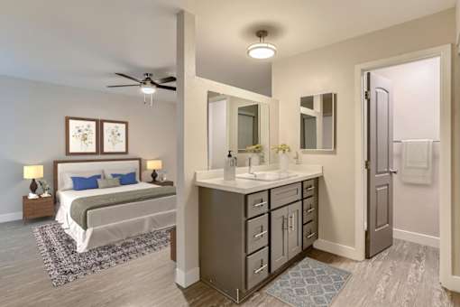 A bedroom with a bed, vanity, and a ceiling fan.