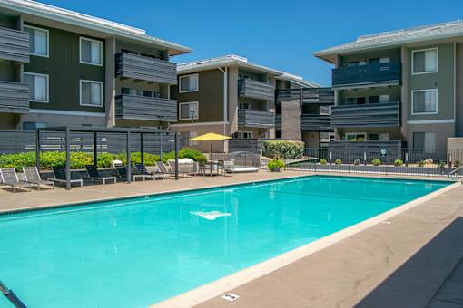 A swimming pool in front of apartment buildings.
