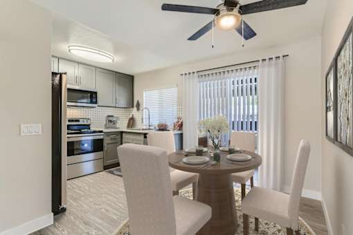 A modern kitchen with a dining table set for two.