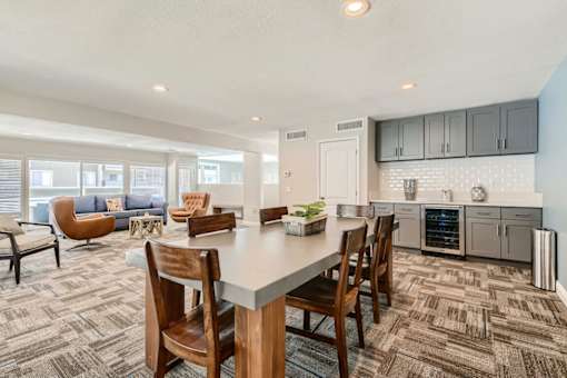 A kitchen with a dining table and chairs in the foreground.