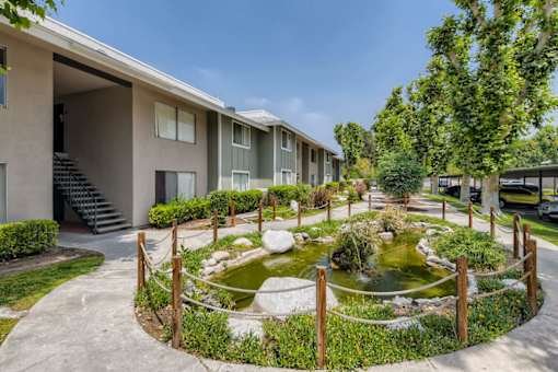 A pond in a courtyard surrounded by a fence.
