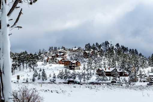 A snowy landscape with a cluster of houses on a hill.
