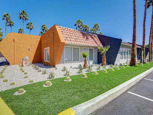 A house with a red tile roof and a yellow front yard.