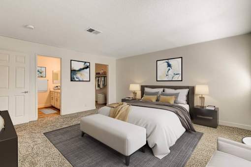 A bedroom with a large bed and a painting on the wall.
