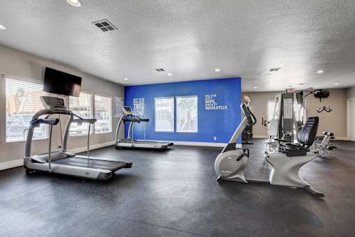 A gym with treadmills and elliptical machines.