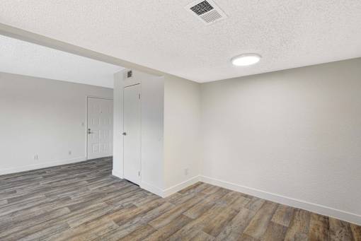 A room with a wooden floor and a white door.