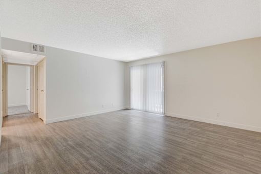 A room with wooden flooring and white walls.