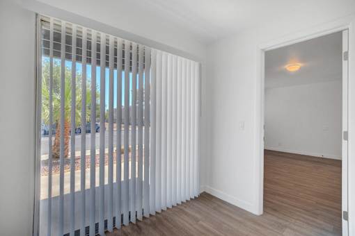 A room with a sliding door and a window with blinds.