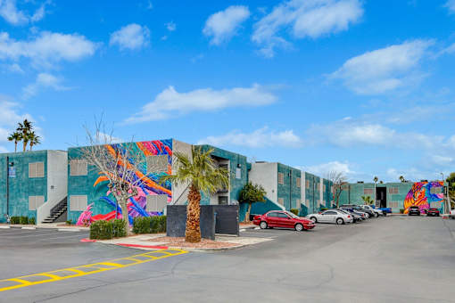 A wall with a colorful mural of a palm tree and a bird.