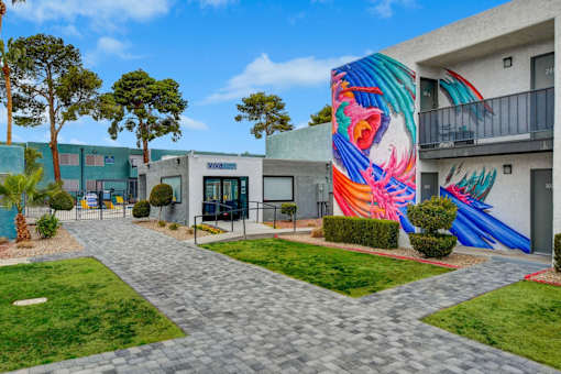 A colorful mural on a building in a sunny courtyard.
