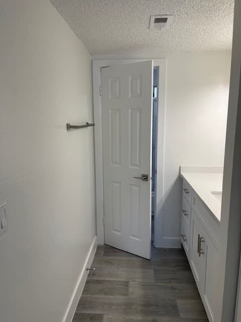 A white door is in a hallway with a counter on the side.