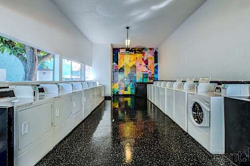 A laundromat with a row of washers and dryers.