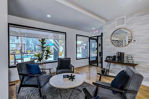 A living room with a black chair and a round table.