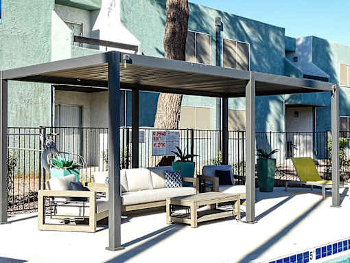 A poolside lounge area with a canopy and seating.
