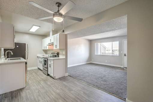 A kitchen with a fan and a dining table.