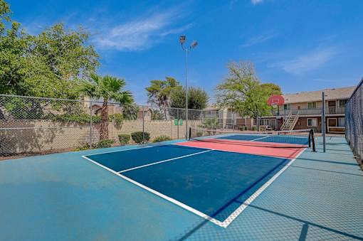 A tennis court with a red and white line in the middle.