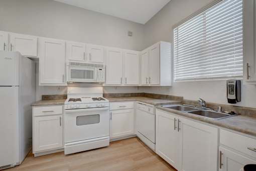A kitchen with white appliances and cabinets.
