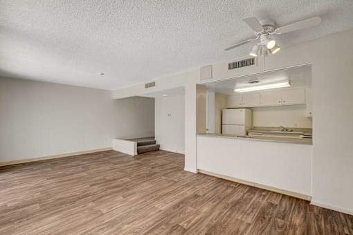 A room with a ceiling fan and wooden flooring.