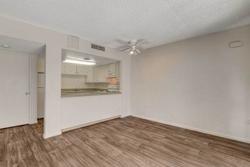A room with a ceiling fan and a mirrored cabinet.