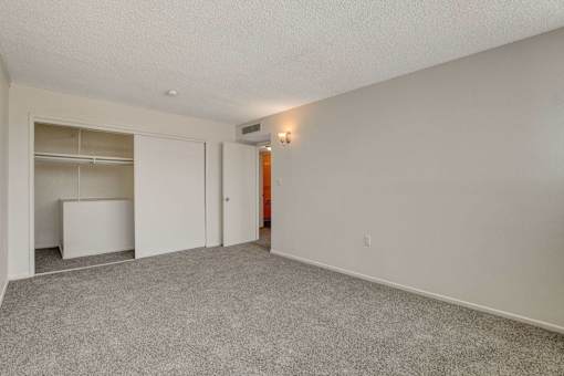 A room with a grey carpet and white walls.