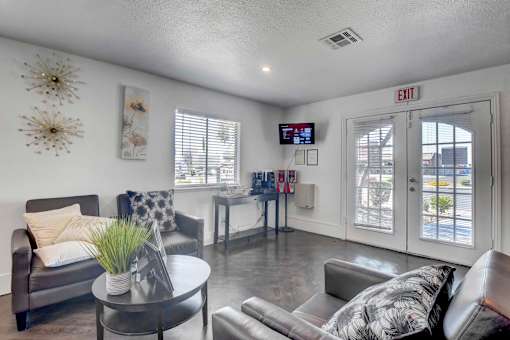 A living room with a grey couch, a coffee table, and a TV screen.