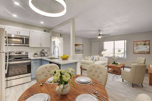 A modern kitchen with a dining table set for two.