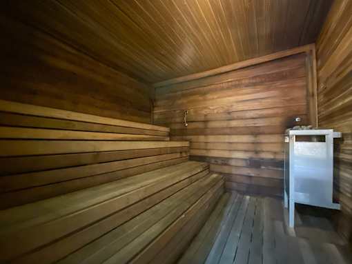 A wooden sauna with a bench and a door.