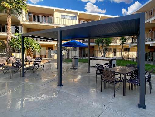 A patio area with tables and chairs under a canopy.