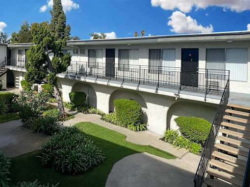 A white building with a balcony and a staircase.