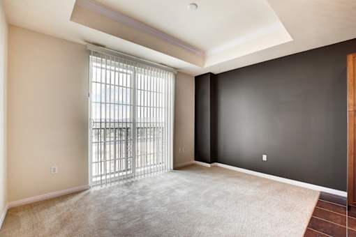 A room with a sliding glass door leading to a balcony.