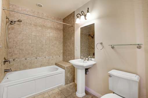 A bathroom with a tub, sink, and toilet.