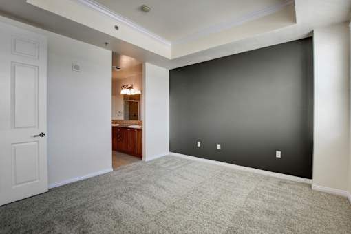 A room with a white door and a carpeted floor.