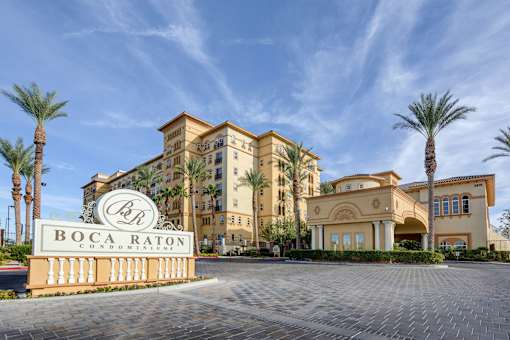 The Boca Raton building is a large, tan, multi-story hotel with palm trees in front.