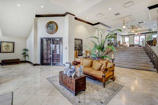 A living room with a couch, a coffee table, and a staircase.