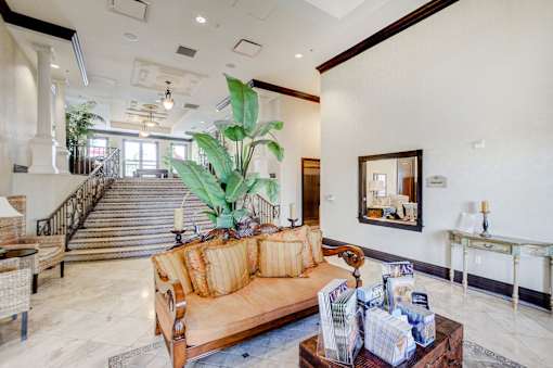A living room with a couch, coffee table, and a staircase.