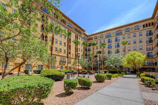A sunny day at a courtyard with a building in the background.