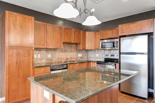 A kitchen with granite countertops and stainless steel appliances.