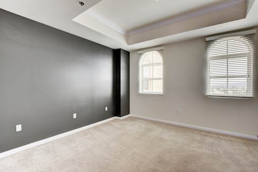 A room with a window and a carpeted floor.
