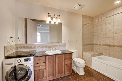 A bathroom with a washer and dryer built into the cabinetry.