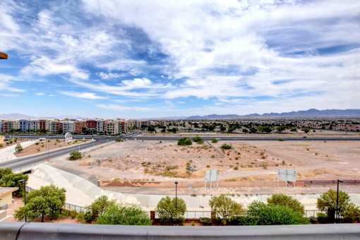 A view of a construction site with a road and buildings in the distance.
