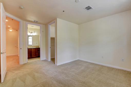 A room with a carpeted floor and a doorway leading to another room.
